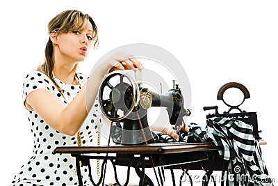 Woman dressmaker pin up style using antique sewing manual machine Stock Photo