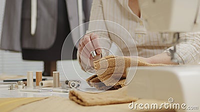 Woman dressmaker working in workshop with tailoring mannequin, sews by hand the sweater. closeup, with tailoring mannequin, Stock Photo