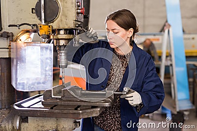 Woman drilling steel structures on drill press Stock Photo