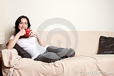 Woman with drink on couch Stock Photo