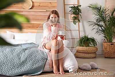 Woman drinking coffee in bedroom with plants. Home design ideas Stock Photo