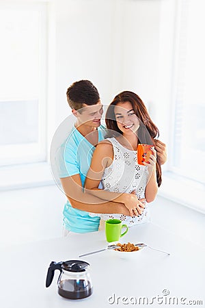 Woman drinking coffee and her husband hugging her Stock Photo