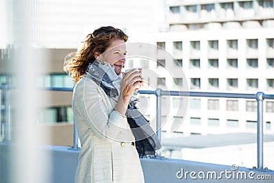 Woman drinking coffee by railing Stock Photo