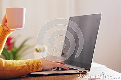 Woman drinking coffee while working on her laptop Stock Photo