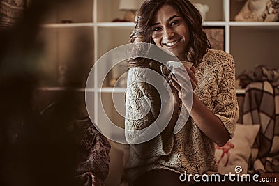 Woman drinking a cup of tea at home - Christmas Stock Photo