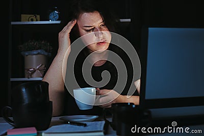 Woman drinking too much coffee at night work Stock Photo