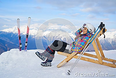 Woman drinking warm tea in the rustick wooden terrace on mountain, alpine view, snow on hills Stock Photo