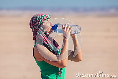 Woman drinks water in the desert of Egypt. Hot weather concept Stock Photo