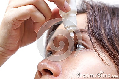 Woman dripping eye with eyes drops Stock Photo