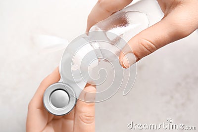 Woman dripping solution into contact lens case Stock Photo