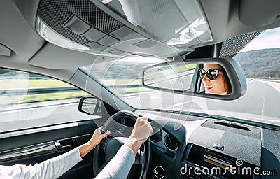 Woman drive a car reflects in back view mirror Stock Photo