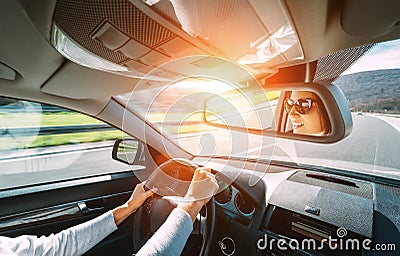 Woman drive a car reflects in back view mirror Stock Photo