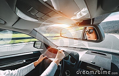 Woman drive a car reflects in back view mirror Stock Photo