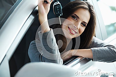 Woman Driver Holding Car Keys siting in Her New Car. Stock Photo