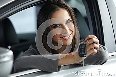 Woman Driver Holding Car Keys siting in Her New Car. Stock Photo