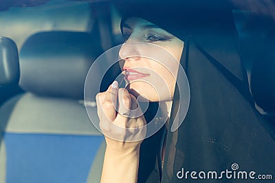 Woman driver paints lips in the car looks in the mirror Stock Photo