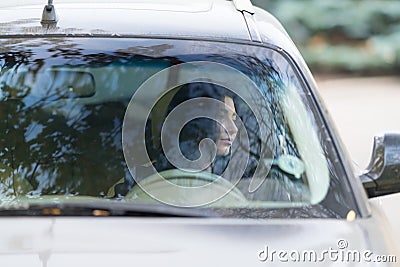 Woman driver sitting waiting in her car. Stock Photo