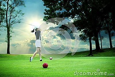 Woman driving golf ball on green golf course Stock Photo