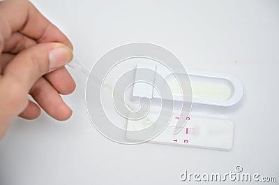 Woman dropping urine pregnancy test Stock Photo