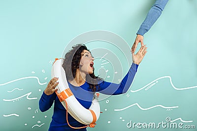 Woman is drowing and ask help with a message of a paper sheet. Cyan background Stock Photo