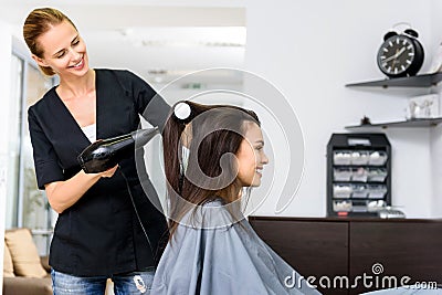 Woman drying hair of her client in salon Stock Photo