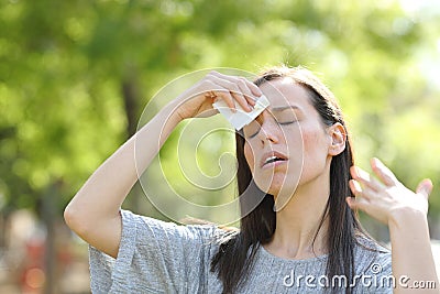 Woman drying sweat using a wipe in a warm summer day Stock Photo