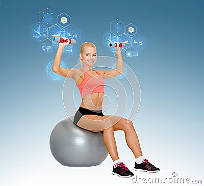 Woman with dumbbells sitting on fitness ball Stock Photo