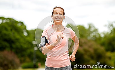 Woman with earphones add armband jogging at park Stock Photo