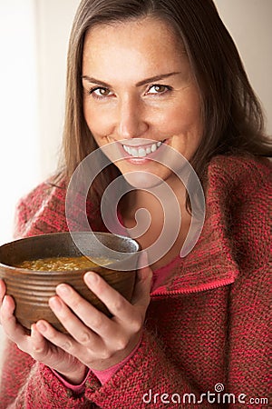 Woman eating bowl of soup Stock Photo