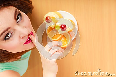 Woman eating cake showing quiet sign. Gluttony. Stock Photo