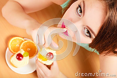 Woman eating cake showing quiet sign. Gluttony. Stock Photo