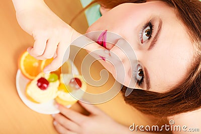 Woman eating cake showing quiet sign. Gluttony. Stock Photo