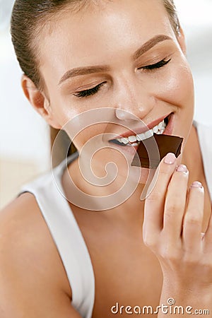 Woman Eating Chocolate. Beautiful Girl With Sweets. Stock Photo