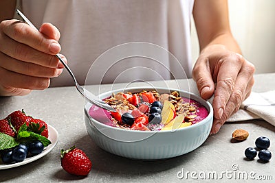 Woman eating delicious acai smoothie, closeup Stock Photo