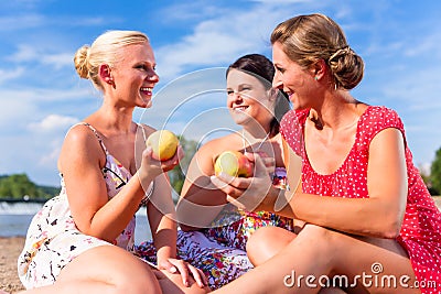 Woman eating fruit at river beach picnic Stock Photo