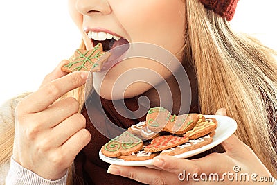 Woman eating gingerbread cookies, Christmas time concept Stock Photo