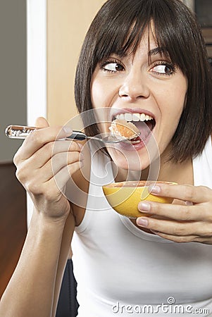Woman Eating Grapefruit Stock Photo
