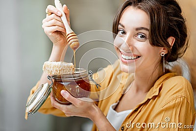 Woman eating honey at home Stock Photo