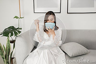 Woman eating instant noodles at night. Stock Photo