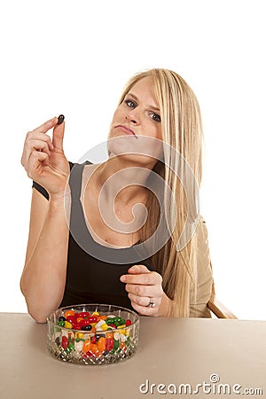 Woman eating jelly beans hold black one Stock Photo