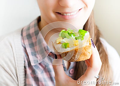 Woman eating sandwich with cheese and green vegetables onion Stock Photo