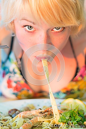 Woman eating seafood noodles. Stock Photo