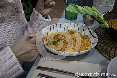 Woman eating a soupy rice. A highly demanded food in Spain Stock Photo