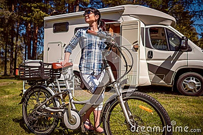 Woman on electric bike resting at the campsite VR Caravan car Va Stock Photo