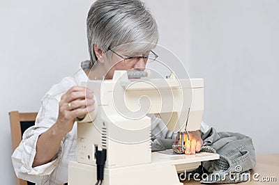 Woman with electric sewing machine Stock Photo