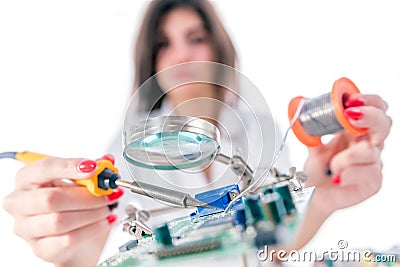 Woman Electronic Technician Repair Electronic Equipment using Electric Soldering Iron Stock Photo