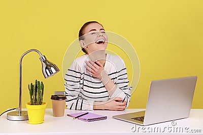 Woman employee laughing out loud, being hysterical at crazy joke on laptop having break at workplace Stock Photo