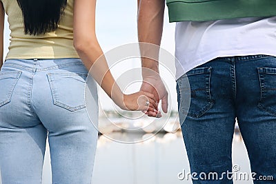 Woman with engagement ring holding hands with her fiance near river, closeup Stock Photo