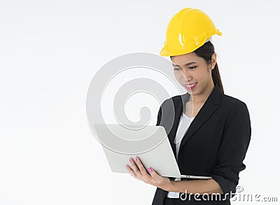 Woman engineers wearing a black suit and Yellow Safety helmet Standing to work with a computer notebook isolated on white backgrou Stock Photo