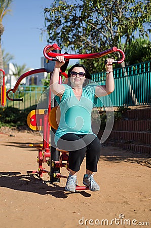 Woman enhancing her arms in fitness station Stock Photo